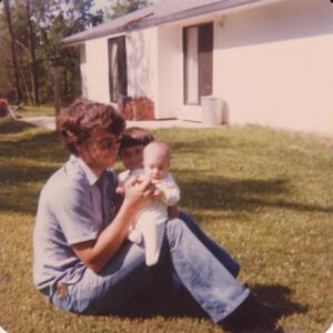 My dad holding me as a baby (brother photo bombing).